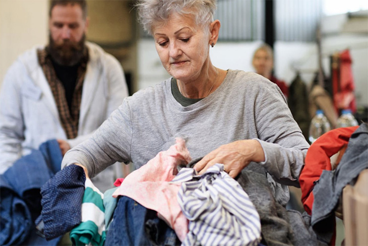 Team member sorting donated clothing for resale and recycling.